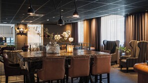 A dining area with a large table, multiple chairs, and a vase with flowers. - Comfort Hotel Skelleftea (Skelleftea)