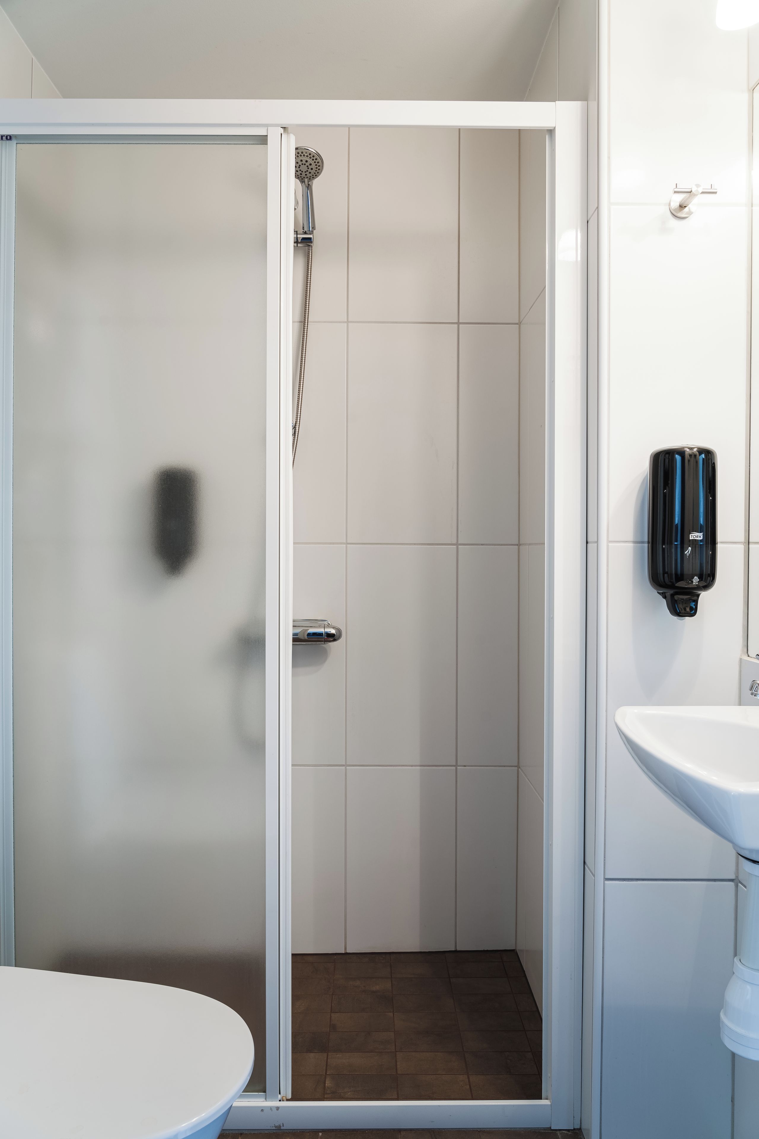 Un baño con ducha, inodoro y lavamanos.