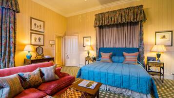 A well-appointed bedroom with a large bed, a red sofa, a chessboard, and a checkered floor.