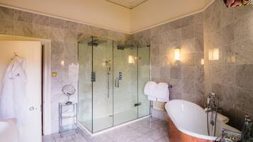 Un baño moderno con ducha envuelta en vidrio, una bañera independiente y un tocador con espejo.