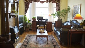 Un salon confortable avec une cheminée, une table basse, un canapé et un téléviseur.
