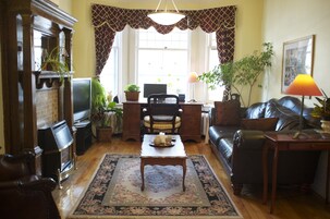 A cozy living room with a fireplace, a coffee table, a sofa, and a television.