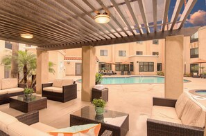 An outdoor pool area with lounge chairs and a covered seating area. - Holiday Inn Express & Suites Carlsbad Beach by IHG (Carlsbad)