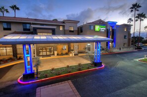 A hotel entrance with a covered waiting area, a sign for the Holiday Inn Express & Suites, and a parking lot with a 'No Parking' sign. - Holiday Inn Express & Suites Carlsbad Beach by IHG (Carlsbad)