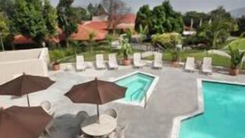 A rooftop pool area with lounge chairs and umbrellas.