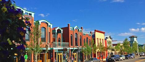 A street lined with colorful buildings, including a restaurant and a bank.