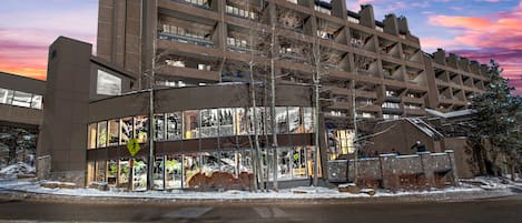 A multi-story parking garage with a modern architectural design, featuring a large glass facade and multiple levels of parking.