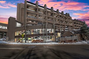 A multi-story parking garage with a modern architectural design, featuring a large glass facade and multiple levels of parking.