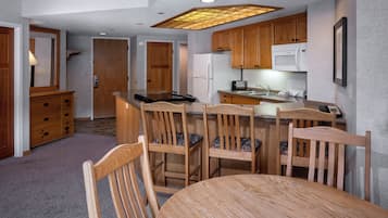 A compact kitchen with wooden cabinets, a microwave, and a refrigerator.