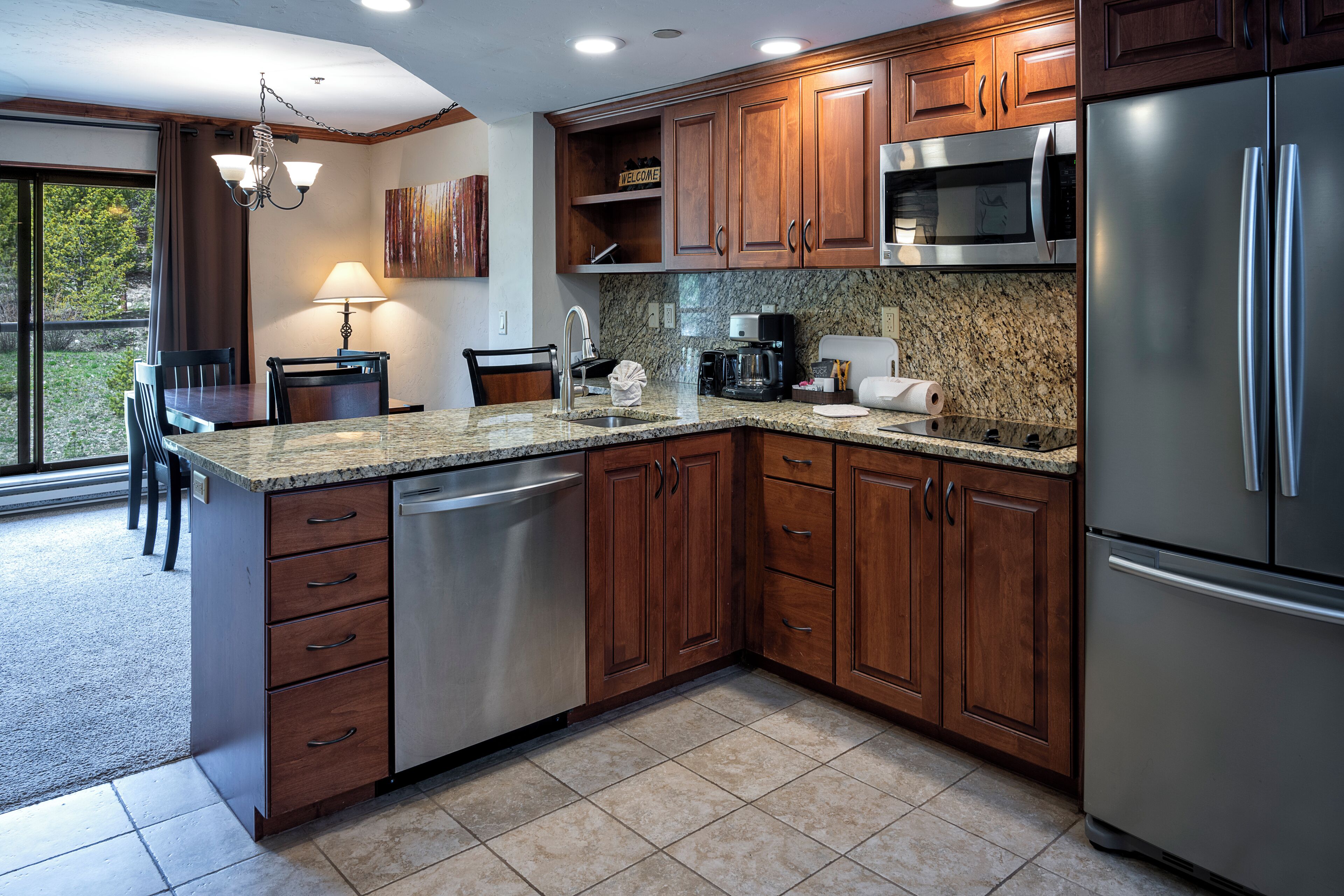 Una cocina moderna con armarios de madera, electrodomésticos de acero inoxidable y encimera de granito.