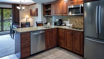 Una cocina moderna con armarios de madera, electrodomésticos de acero inoxidable y encimera de granito.