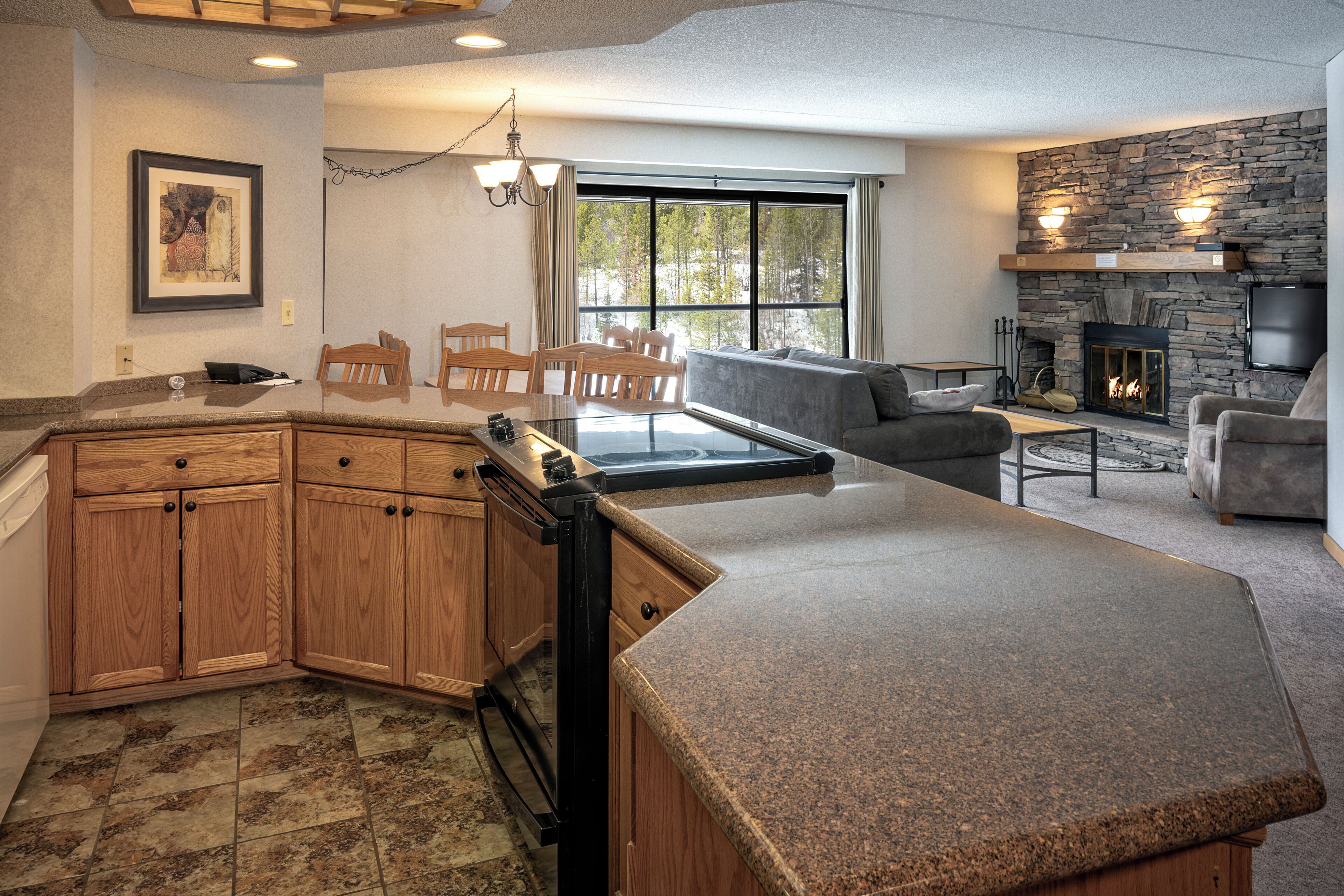 A modern kitchen with granite countertops, wooden cabinets, and a built-in oven.