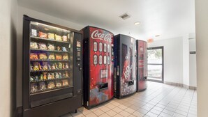 A row of vending machines in a hallway with a tiled floor. - Motel 6 Dallas, TX - Northeast (Dallas)