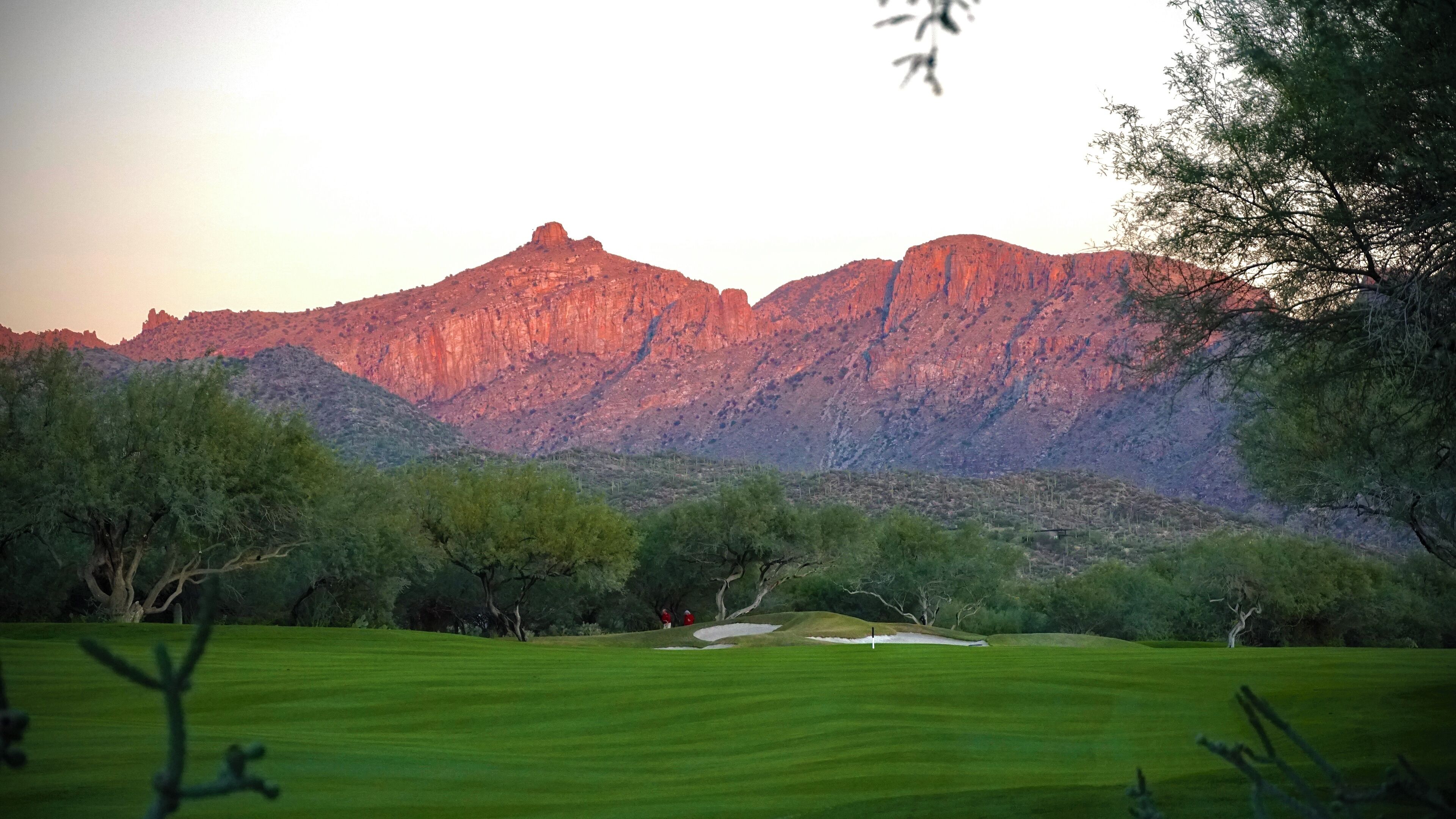 Un campo de golf con montañas al fondo.