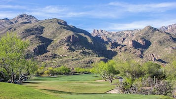 A golf course with a mountainous backdrop.