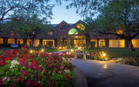 A hotel with a modern architectural design, featuring a central dome and symmetrical wings.