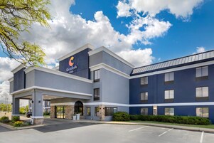 Un hotel moderno con un cartel destacado de 'Courtyard by Marriott', una entrada cubierta y un estacionamiento.