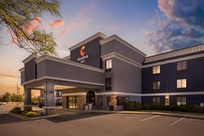 A Comfort Inn hotel with a modern design, featuring a prominent 'Comfort Inn' sign, a covered entrance, and a parking lot.
