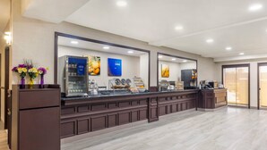 A modern hotel reception area with a long counter, a refrigerator, and a coffee station.