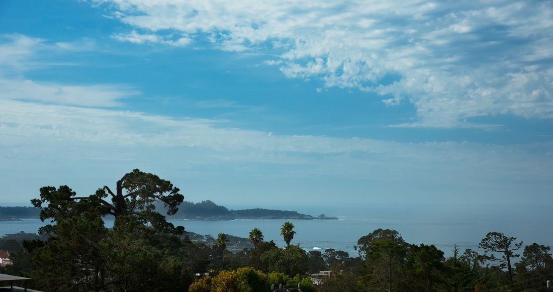 A coastal landscape with a view of the sea and distant land.