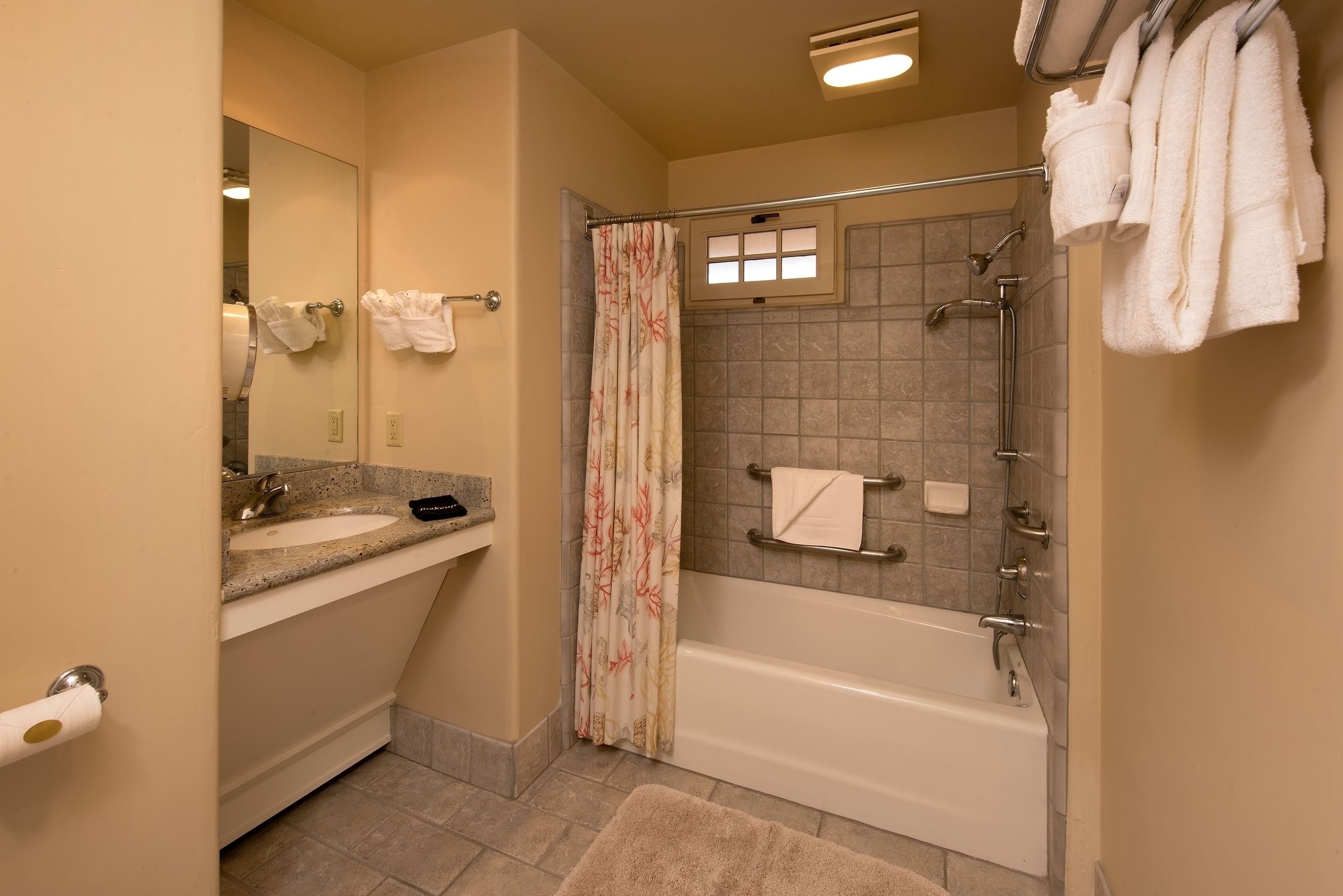 A bathroom with a sink, mirror, towel rack, shower, and bathtub.