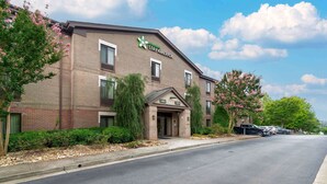 A Stay America hotel with a brick facade, a lobby entrance, and a parking area. - Extended Stay America Select Suites Atlanta Alpharetta Norpt (Alpharetta)