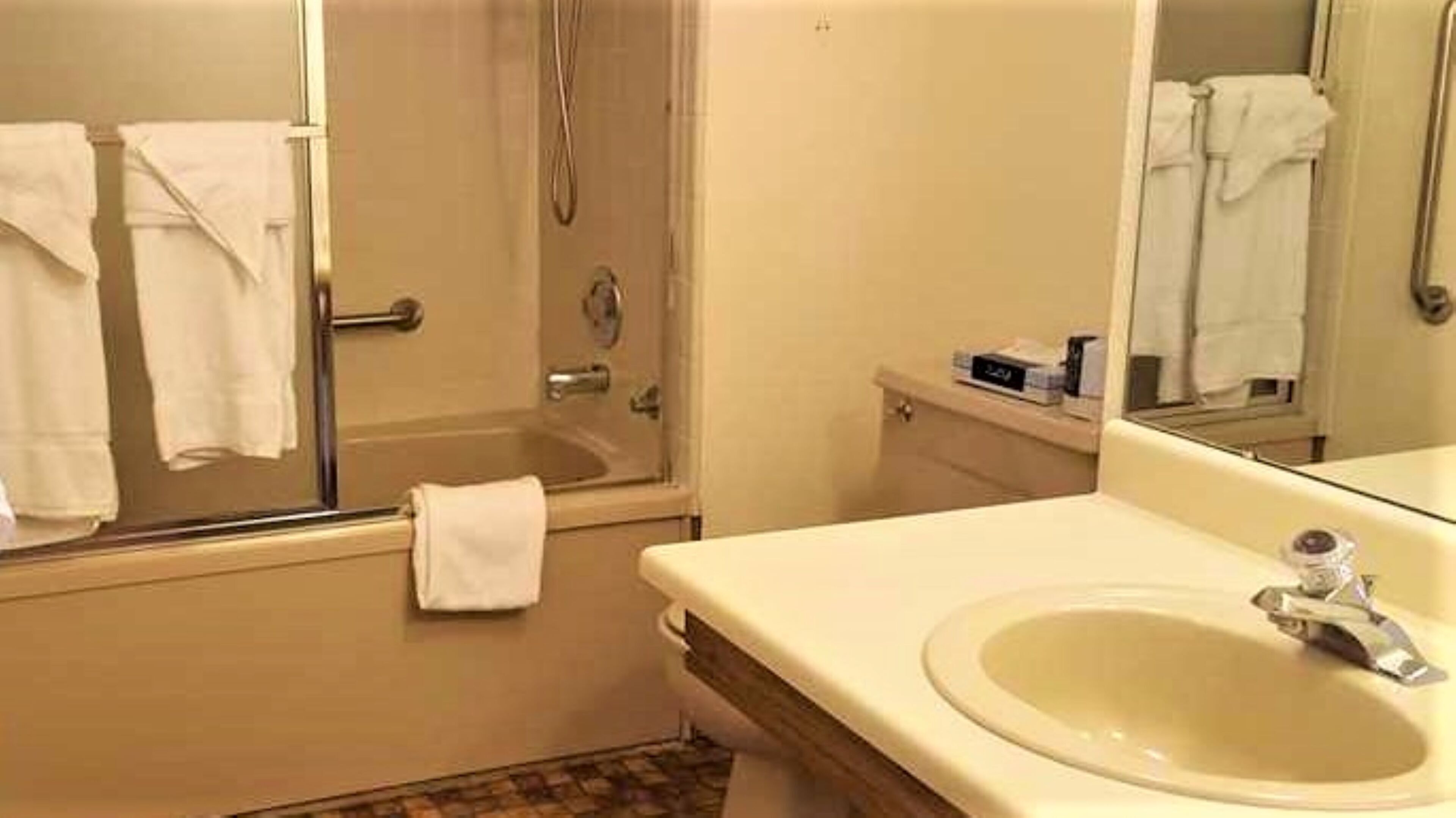Une salle de bain avec une baignoire, un lavabo et un miroir.