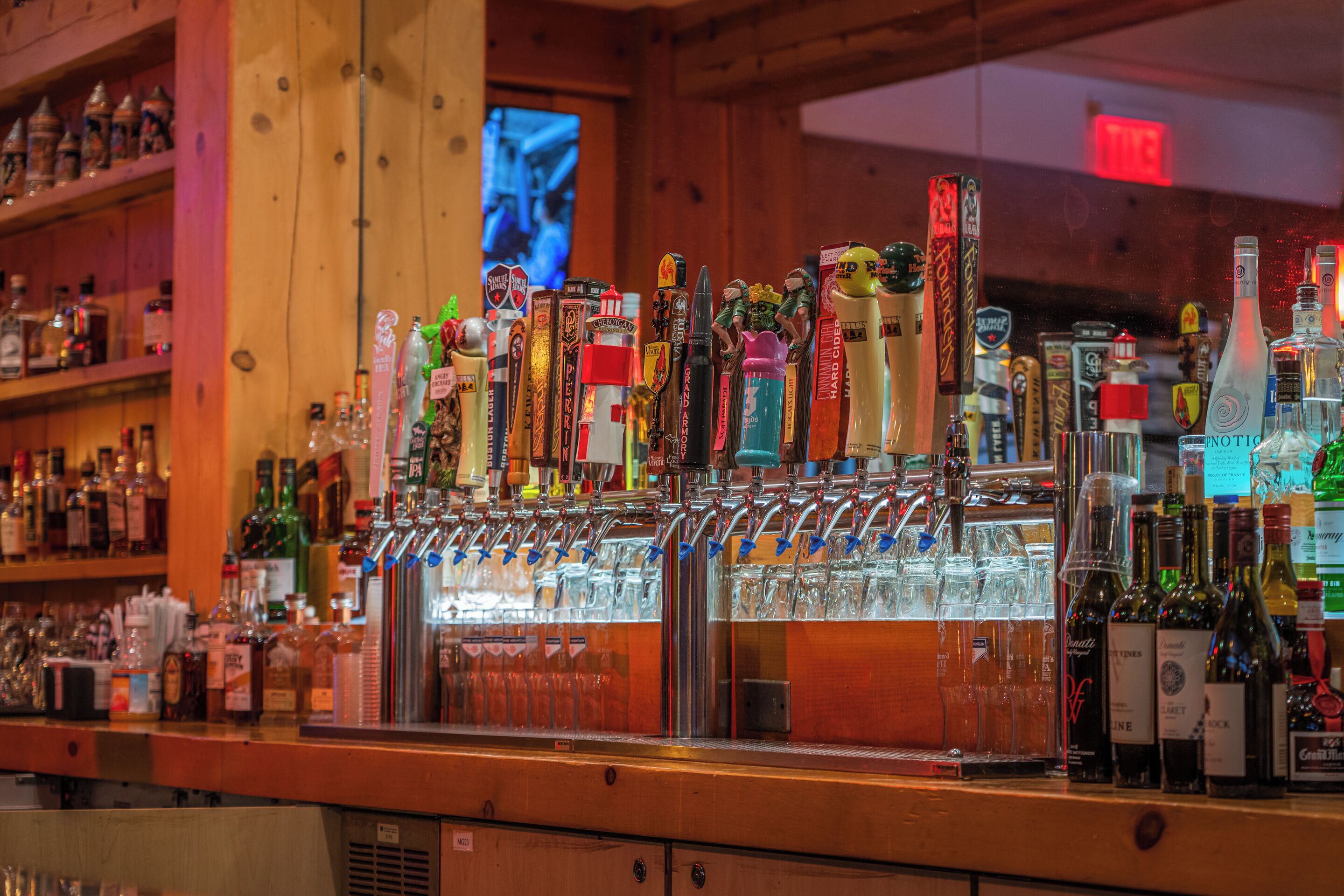 Un bar proposant un large choix de boissons alcoolisées, avec de nombreux robinets et bouteilles.