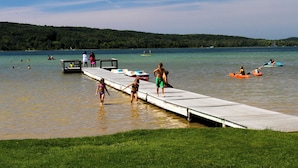 Une jetée s’avançant dans un lac, où des personnes pratiquent des activités nautiques.
