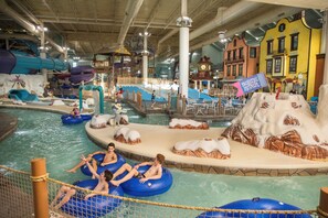 An indoor water park with inflatable tubes, slides, and a snowy mountain play area.