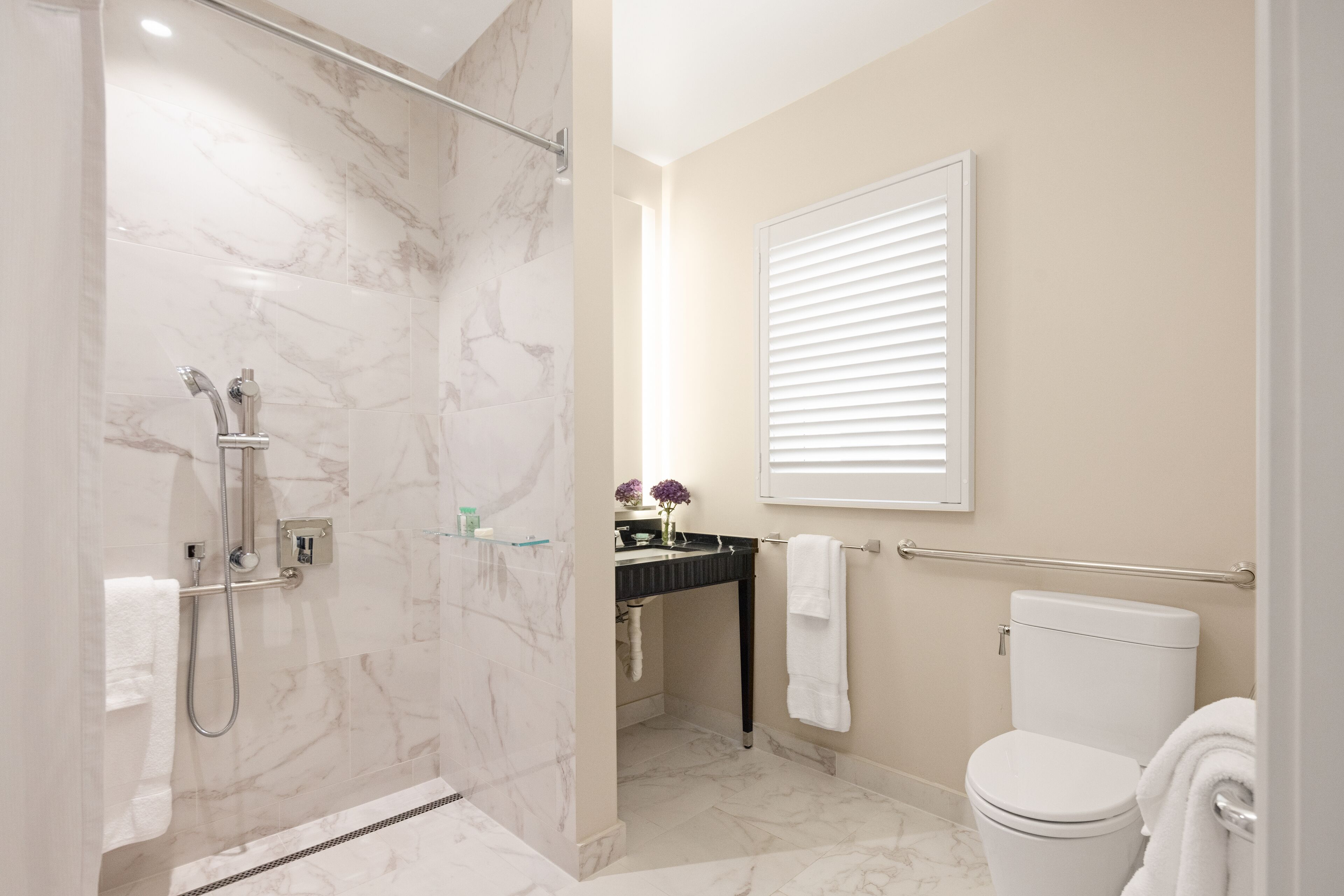 A modern bathroom with a shower, toilet, and sink.