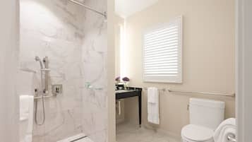 A modern bathroom with a shower, toilet, and sink.