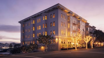 A multi-story hotel with a classic architectural style, featuring a symmetrical facade, multiple windows, and a corner entrance.