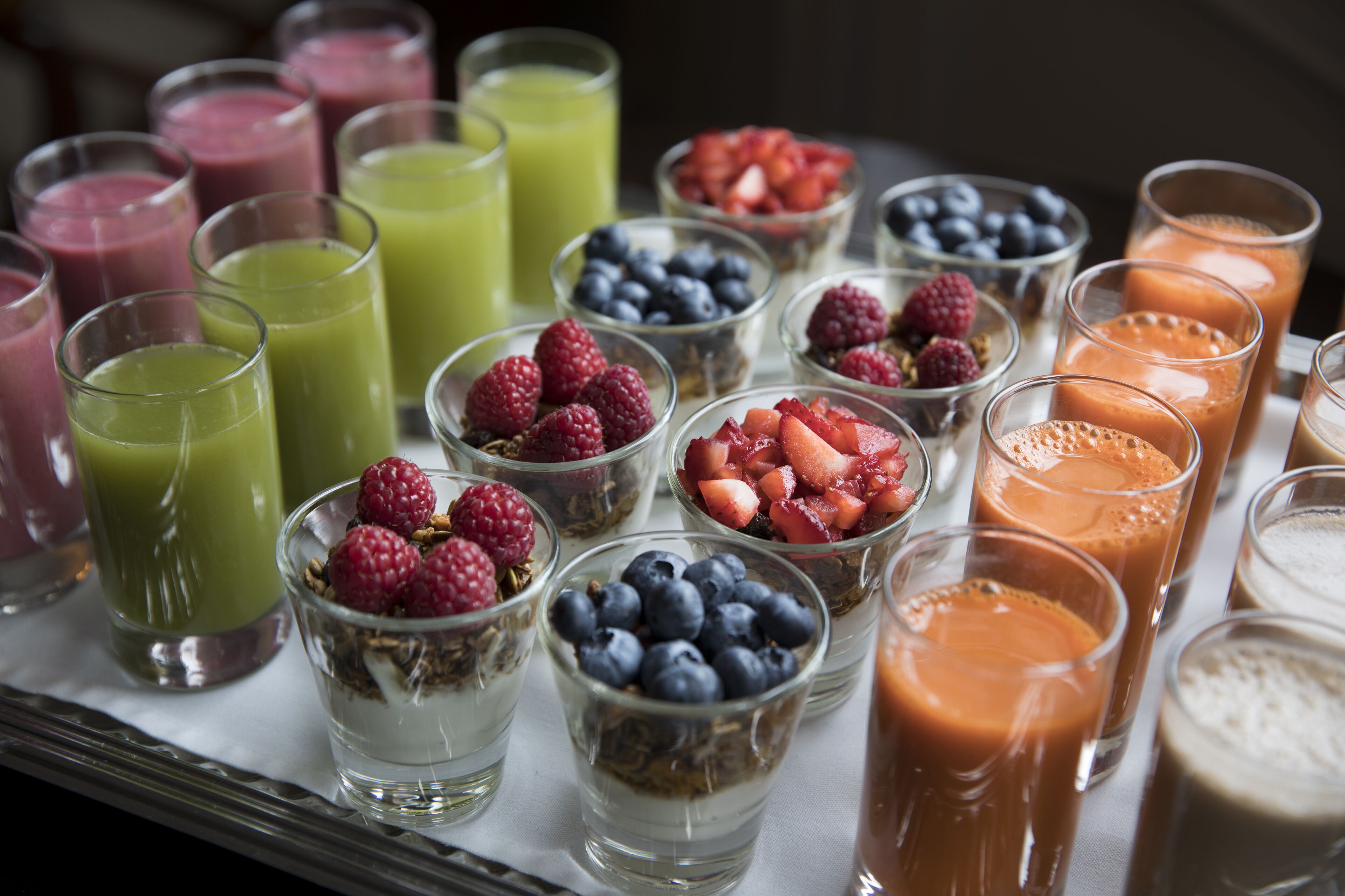 A variety of beverages and fruit bowls on a tray.