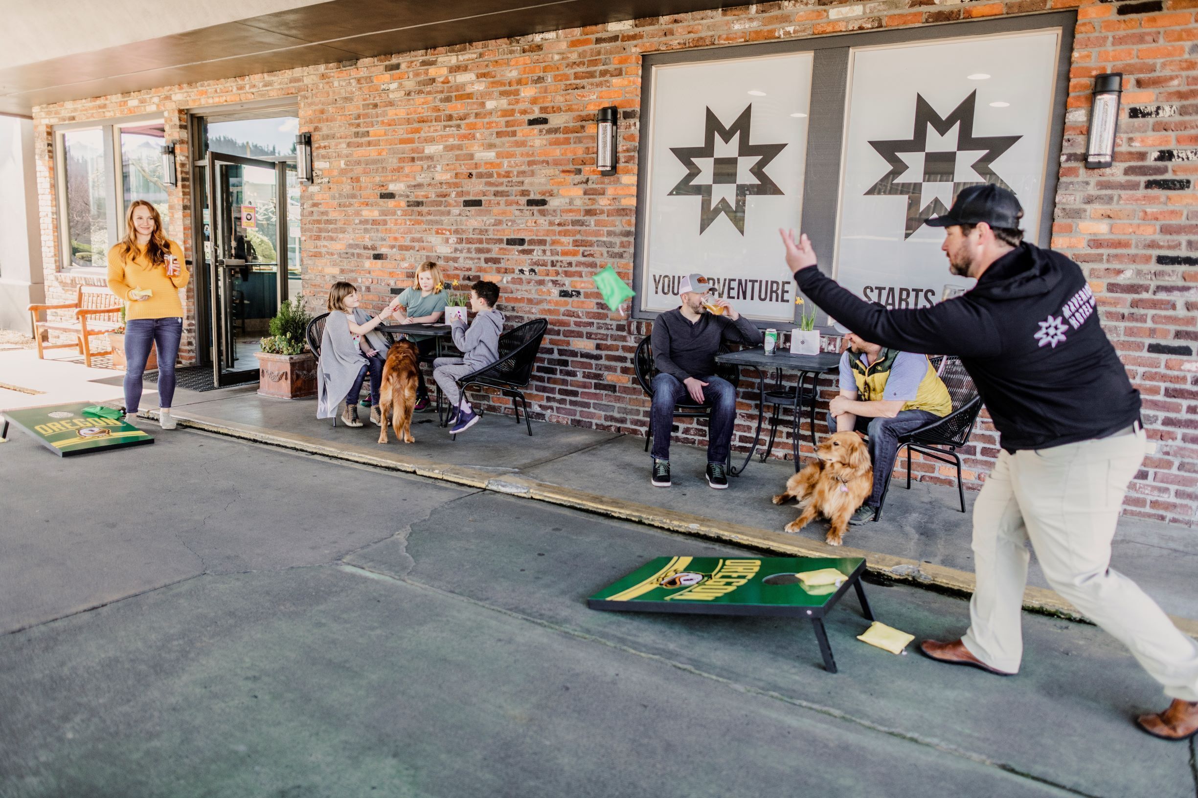 An outdoor seating area with brick walls, a green table with a game, and a poster with a star and text.
