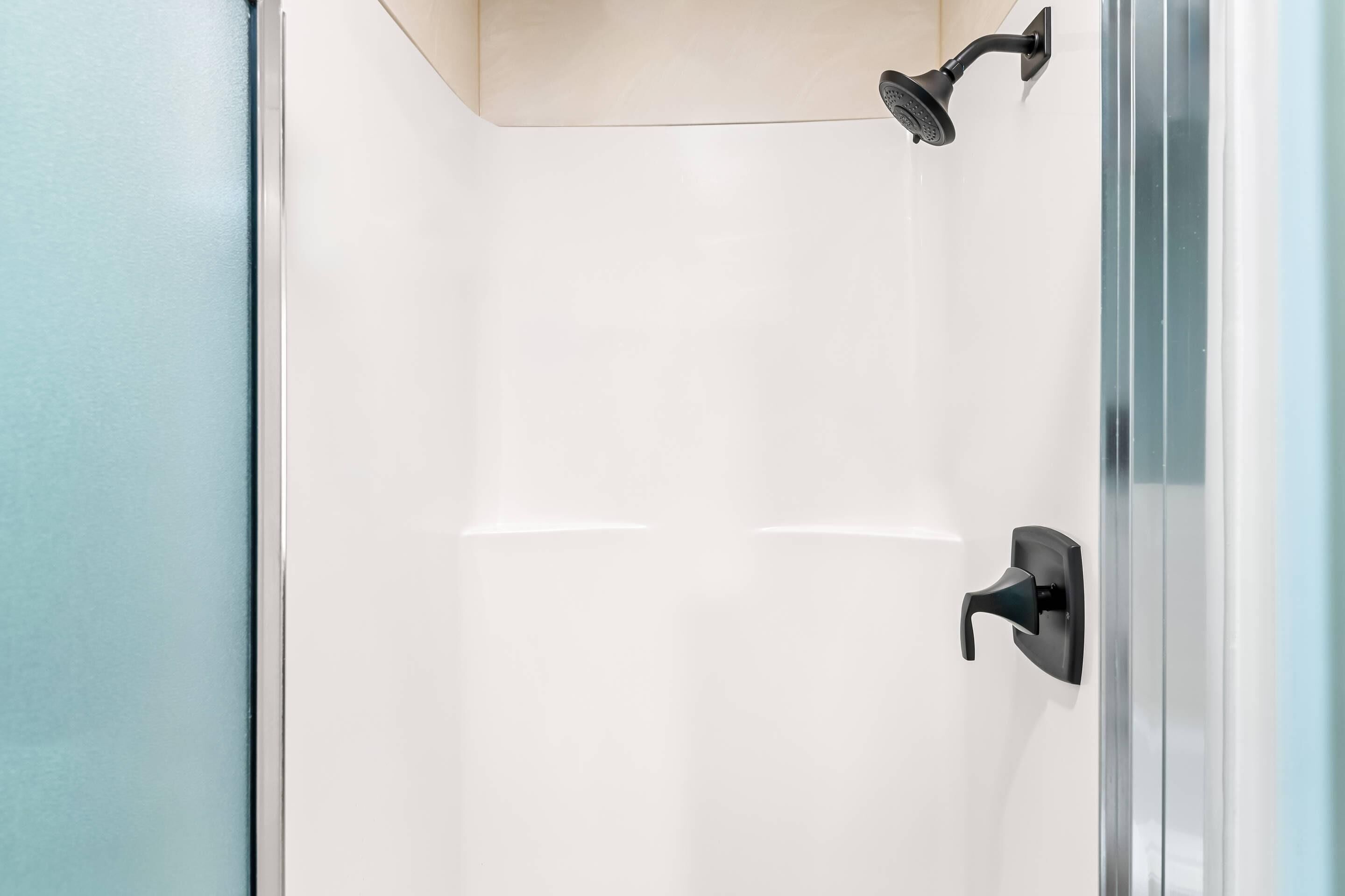 Ducha moderna con cabezal de ducha manual y grifería empotrada.