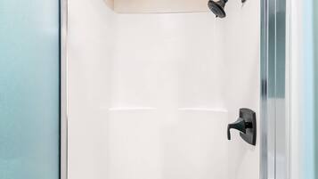 Ducha moderna con cabezal de ducha manual y grifería empotrada.