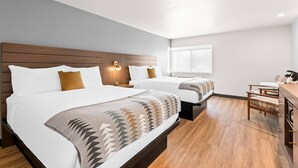 A hotel room with two beds, a wooden headboard, a desk with a chair, and a window. - Maverick Hotel Eugene Near University, an Ascend Collection Hotel (Eugene)