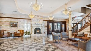 Eine geräumige Lobby mit Schachbrettmuster-Boden, einem Kamin und einer Treppe.