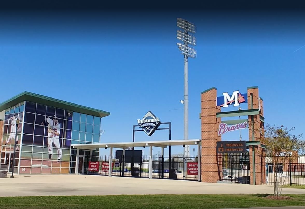 A baseball stadium with a Trustmark sign, a Braves sign, and a Moravese sign.