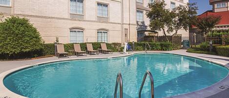 A swimming pool with lounge chairs and a sign indicating a 5ft depth.