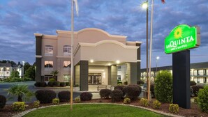 A La Quinta Inn & Suites hotel with a modern facade, a well-lit entrance, and a landscaped garden area. - La Quinta Inn & Suites by Wyndham Florence (Florence)