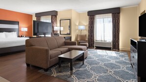 A hotel room with a bed, sofa, TV, and a desk. - La Quinta Inn & Suites by Wyndham Florence (Florence)