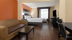 A hotel room with a bed, a sofa, a desk, and a TV. - La Quinta Inn & Suites by Wyndham Florence (Florence)