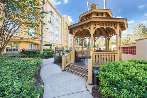 A gazebo with steps leading up to it, surrounded by greenery and a pathway. - La Quinta Inn & Suites by Wyndham Tampa Brandon Regency Park (Brandon)