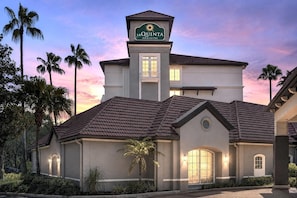 A hotel with a prominent sign, a central tower, and a well-lit facade. - La Quinta Inn & Suites by Wyndham Tampa Brandon Regency Park (Brandon)