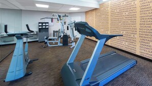 Une salle de sport équipée de tapis de course, d’un vélo d’appartement et d’appareils de musculation.