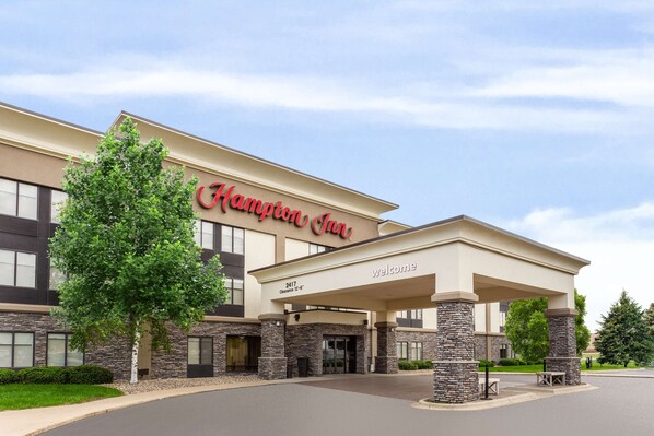 A Hampton Inn hotel with a modern facade, stone pillars, and a welcoming entrance.