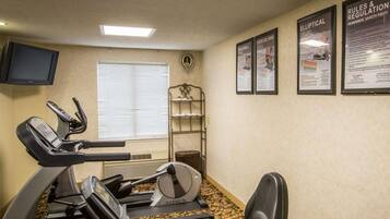 A fitness room with treadmills, an elliptical, and a wall-mounted TV.