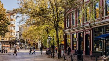 A street scene with pedestrians, bicycles, and buildings with storefronts.